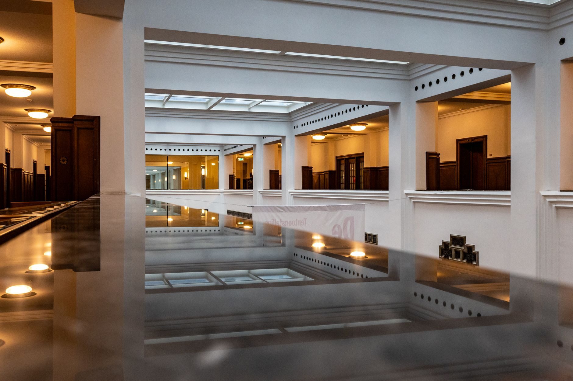 Grand American commercial lobby with marble floors, classical columns, and warm overhead light