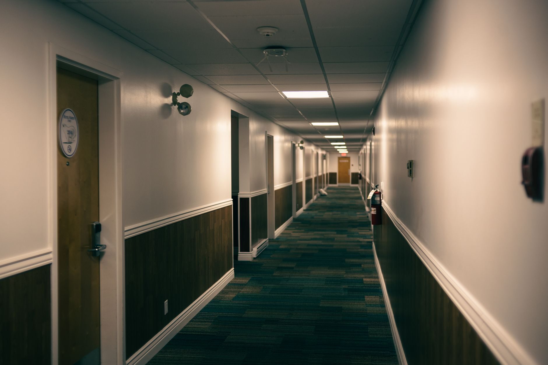 Classic American business-hotel hallway with warm lighting and doors receding to the vanishing point